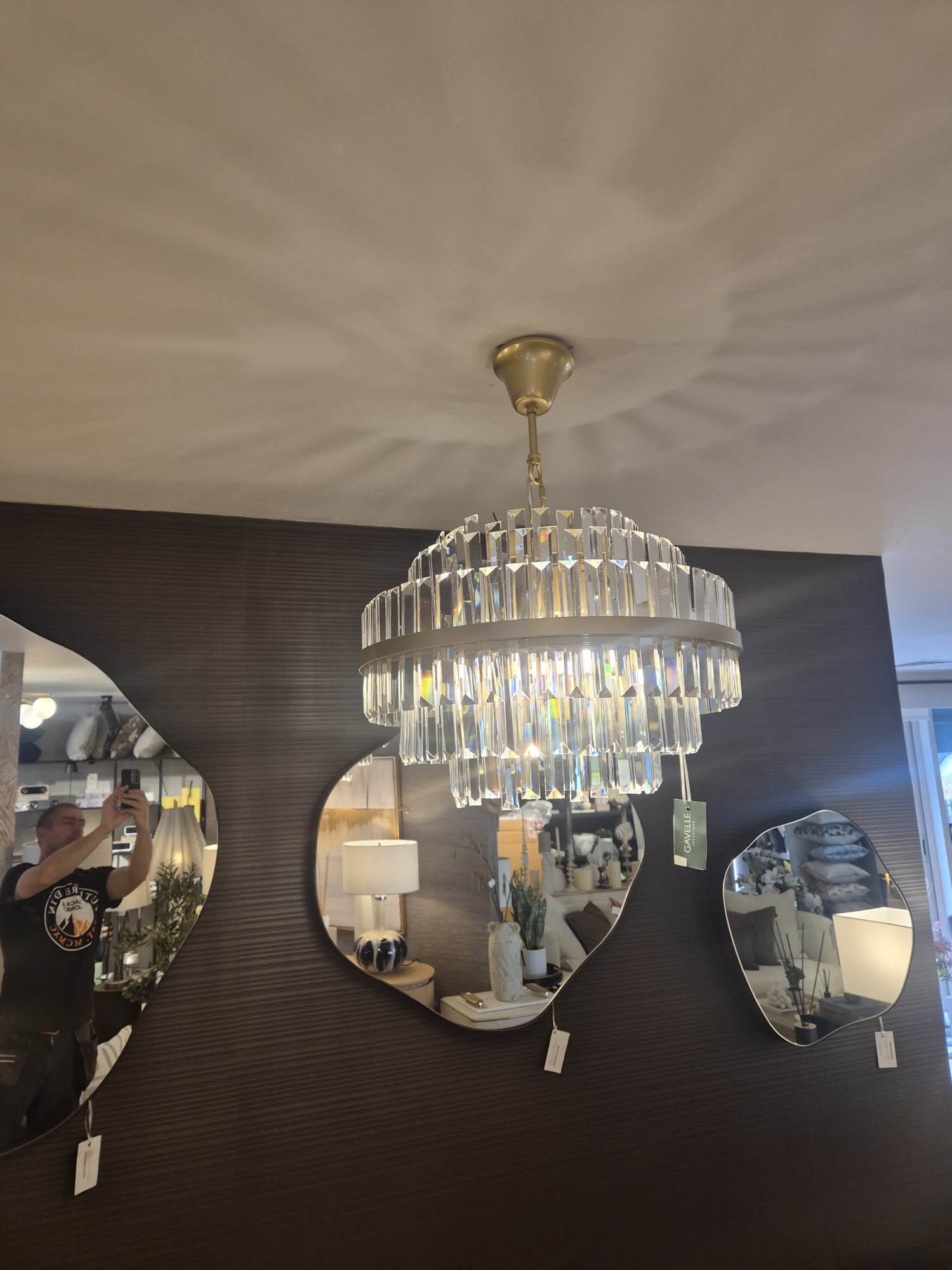 Crystal tiered chandelier hung and levelled in a showroom.
